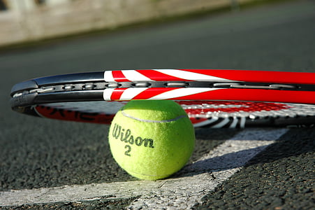 green Wilson tennis ball under tennis rack thumbnail