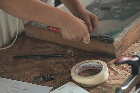 person cutting board beside tape thumbnail