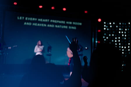 person standing on stage holding guitar thumbnail