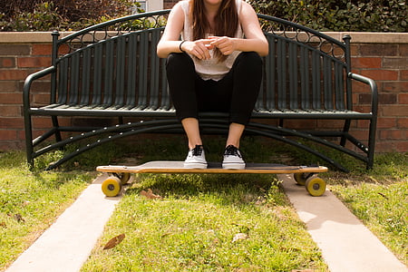 woman sitting on bench with feet resting on a longboard thumbnail