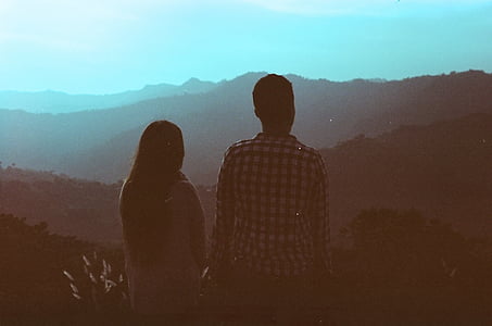 man and woman standing in front of mountain thumbnail
