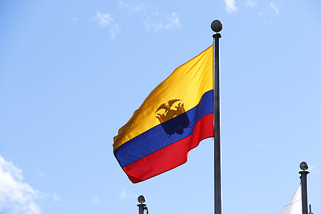 blue, yellow, and red flag waving on pole during daytime thumbnail