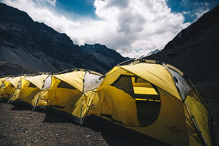five yellow-and-grey tents on mountain thumbnail