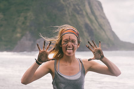 woman smiling while tongue raising both hands near shore thumbnail