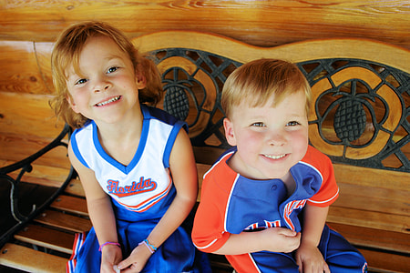 two children sitting beside eachother on bench thumbnail