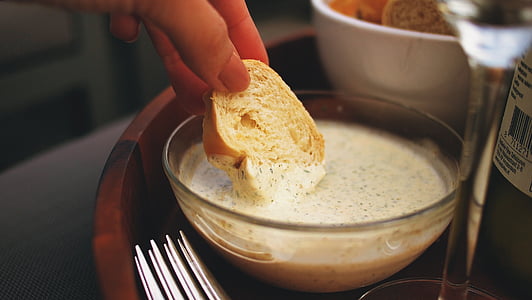 person holding sliced of bread dipped in cream with bowl thumbnail