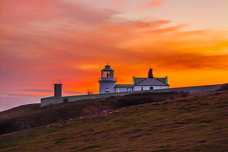 lighthouse under sunset sky thumbnail