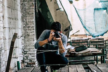 man in gray sweater taking picture of barbwire thumbnail