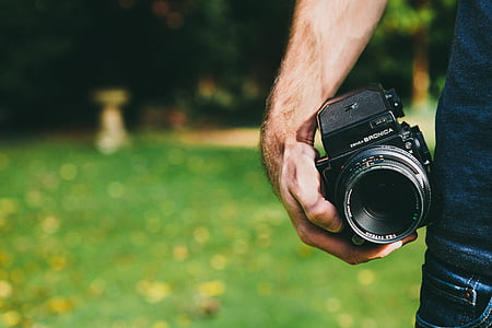 person holding black DSLR camera thumbnail