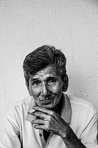 grayscale photography man smoking white cigarette thumbnail