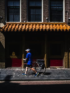 woman walking with road bike on sidewalk at daytime thumbnail
