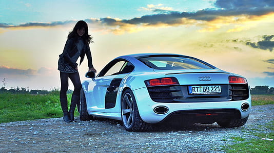 woman leaning on silver Audi R8 parkedo on rough road thumbnail