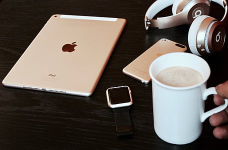 person holding white ceramic mug near silver iPad thumbnail