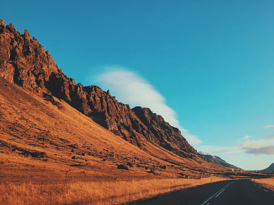 concrete road beside mountain at daytime thumbnail