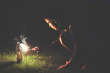 man doing fire stick on grass field at night thumbnail