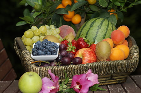 assorted fruits on rectangular brown bamboo basket on brown wooden surface thumbnail