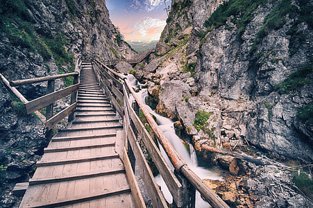 brown wooden footbridge between gray rocky mountain thumbnail