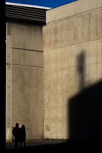 two persons standing near brown wall thumbnail