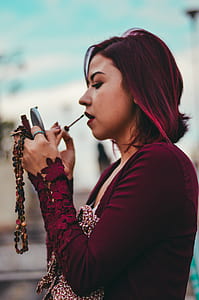 woman putting lipstick on her lips thumbnail