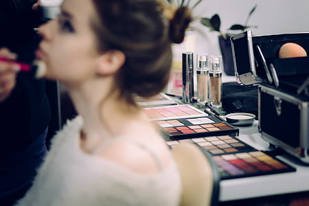 woman doing makeup while sitting on chair thumbnail
