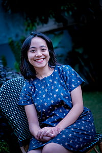 woman looking at the camera while sitting on black patio chair thumbnail