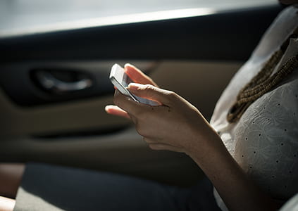 woman wearing white top while using phone thumbnail