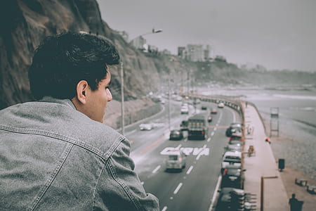 filtered photography of man on bridge looking on road with cars thumbnail