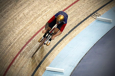 man riding bike on beige track field thumbnail