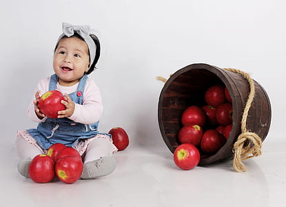 baby girl holding red apple thumbnail