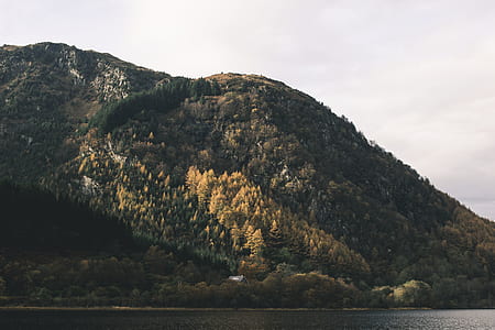 green mountain near body of water at daytime thumbnail