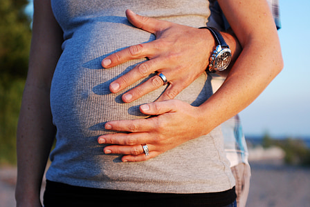 pregnant woman with his husband holding her belly thumbnail