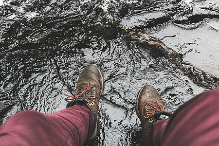 person wearing pair of brown leather shoes beside body of water thumbnail