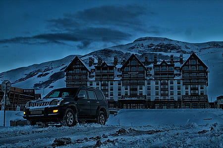 black vehicle near building during night time thumbnail