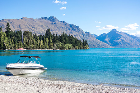 white boat on shore during daytime thumbnail