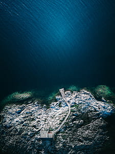 aerial photography of body of water with house on island thumbnail