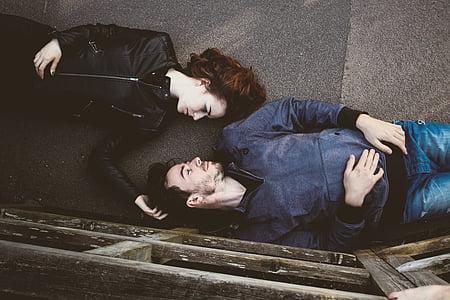 man and woman lying on asphalt floor thumbnail