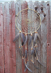 brown and gray dreamcatcher hanged on brown wooden fence thumbnail