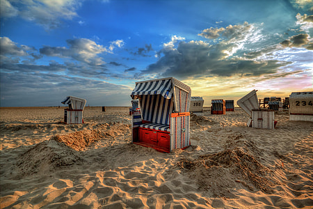 blue and white sheds with cushions on brown sand panoramic photo thumbnail
