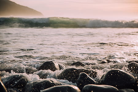 gray stones in ocean during daytime thumbnail