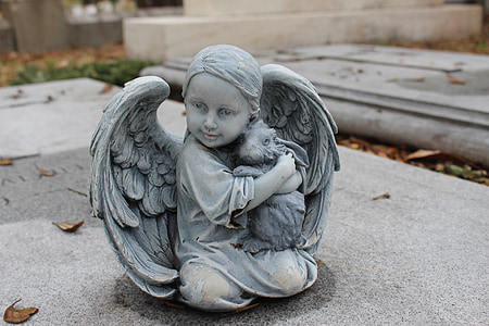 angel holding rabbit sculpture on gray concrete surface thumbnail
