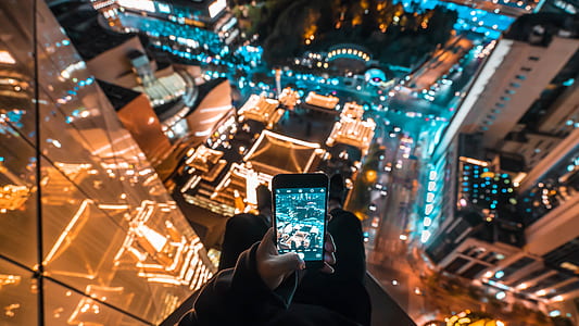 person holding black smartphone displaying camera thumbnail