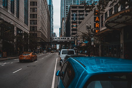 Blue Car on Concrete Road Near Concrete Buildings thumbnail