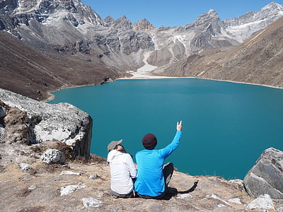 two person sitting in front of blue water thumbnail