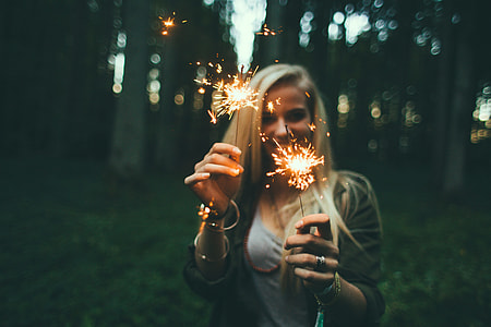 depth of field photography of a woman holding two sparklers thumbnail