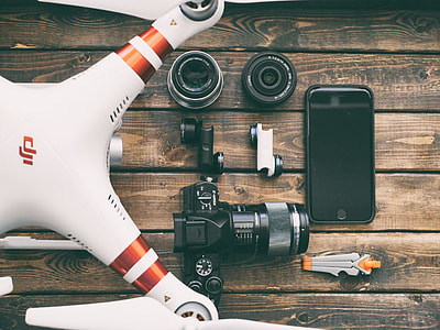 white and red DJI phantom beside black DSLR camera thumbnail