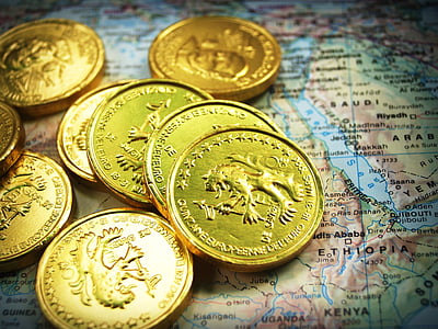 gold-colored coins on top of world map thumbnail