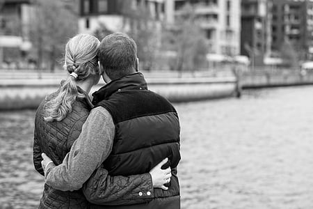 man and woman standing beside body of water thumbnail