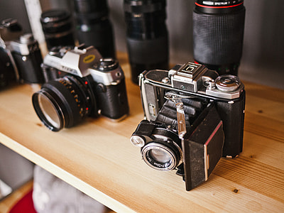 two black-and-gray assorted cameras on the brown wooden table thumbnail