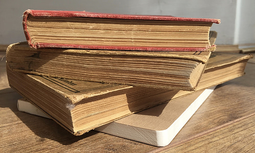 four assorted books on brown wooden surface thumbnail