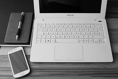 turned off screen of Asus laptop near smartphone and retractable pen thumbnail
